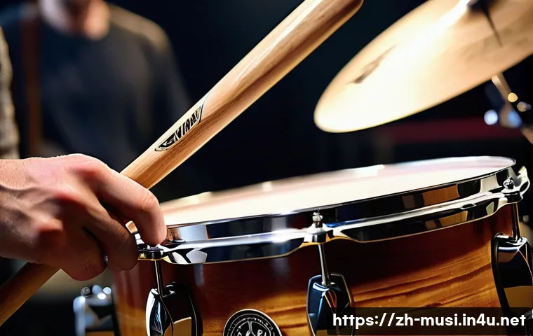 드럼 스틱 종류와 선택법 - A close-up scene of a professional drummer&rsquo;s hands gripping maple wood drumsticks with natural wood ...